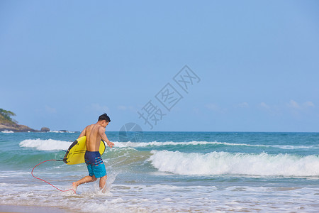 男士泳装男青年抱着冲浪板奔向大海背景