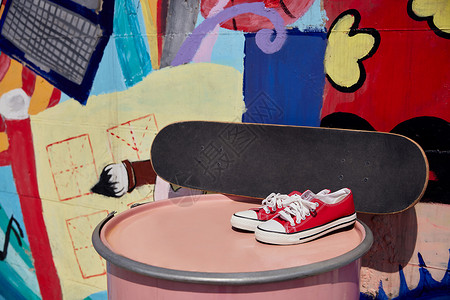 街头涂鸦墙边的滑板帆布鞋高清图片