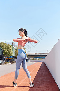 青年女性跑步做手臂热身运动图片