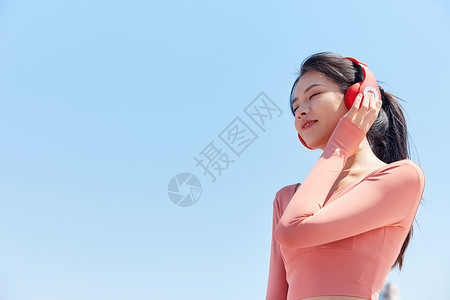 青年女性跑步运动戴耳机休息背景