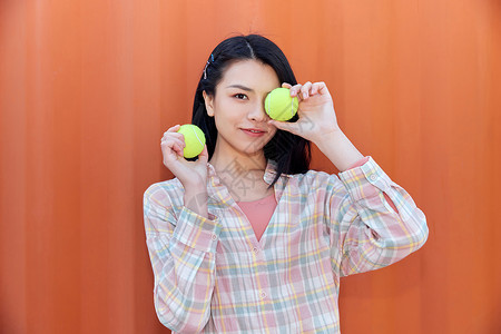 青年活力女性手拿网球背景图片