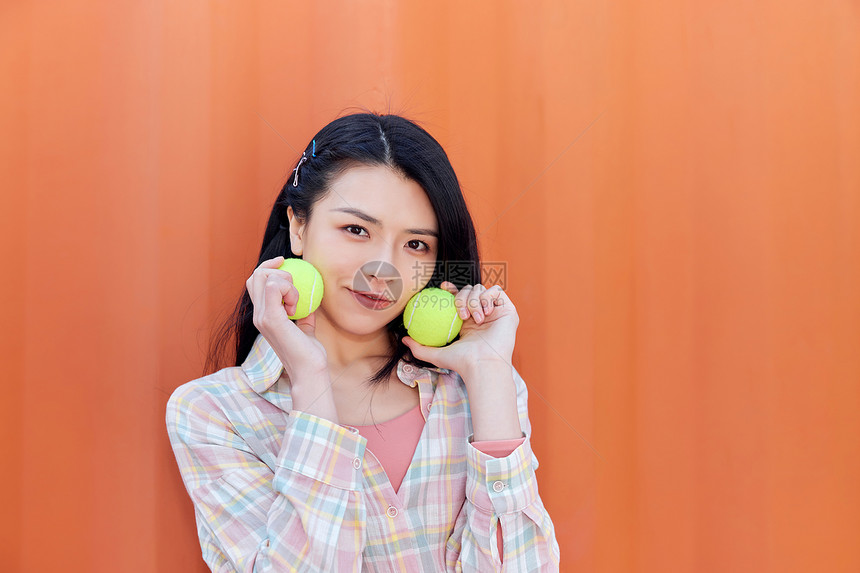 青年活力女性手拿网球图片