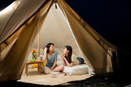 在帐篷内欢笑的朋友闺蜜背景图片