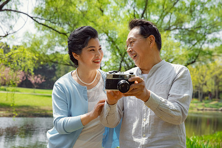 踏青的老年夫妇公园拍照图片