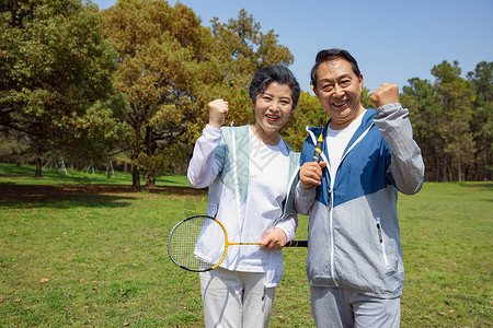 老年人在公园老年夫妇在公园打羽毛球背景