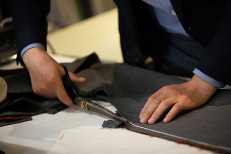 商务服装布料正在工作的裁缝师傅裁剪布料背景