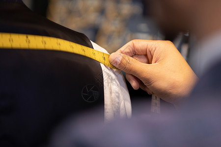 西装设计师服装设计师测量肩宽特写背景