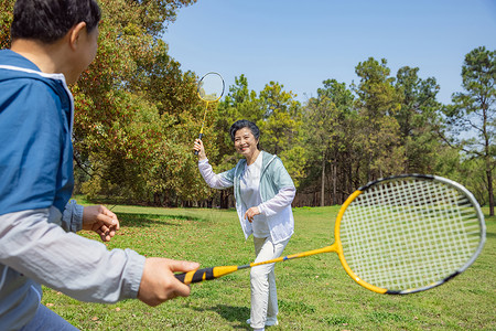 运动白天【精】老年夫妇在公园打羽毛球背景