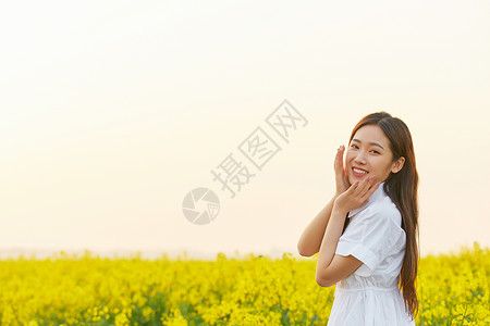 笑的姑娘在油菜花田散步的年轻女性背景
