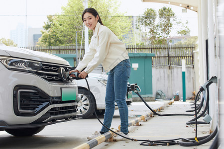 女性给新能源汽车充电图片