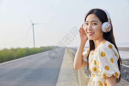 带耳机听音乐的美女户外带耳机的年轻女性背景