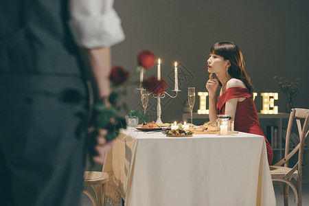 等待爱情餐桌上等待的女生和手拿玫瑰的男生背景
