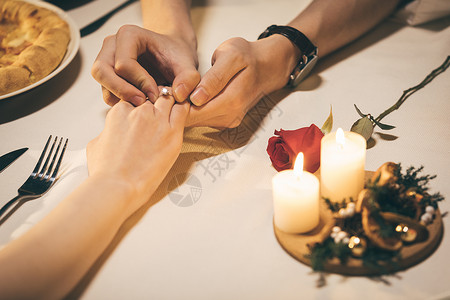 餐桌上的情人节情侣餐桌上戴戒指背景