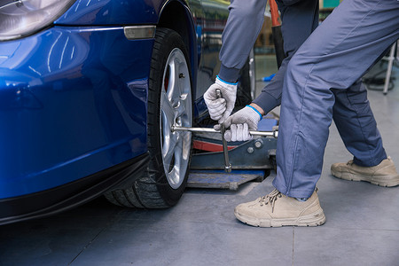汽车修理工人拆卸更换轮胎高清图片