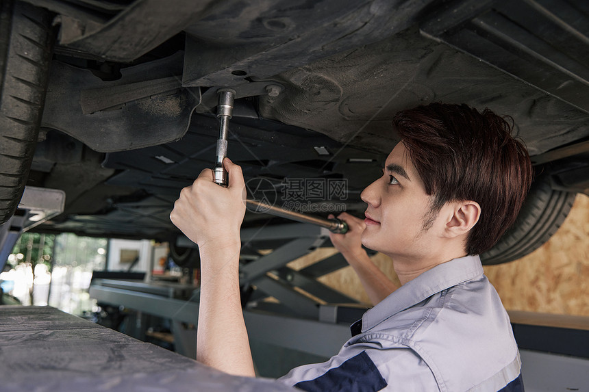 男性汽车修理工修理汽车底盘图片