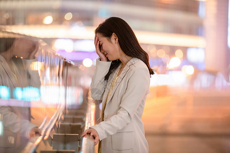 女性、捂脸城市里捂脸伤心难过的女性背景