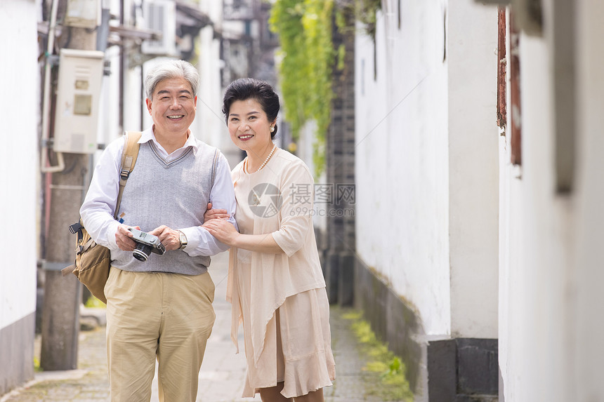 老年夫妻古镇巷子游玩拍照图片