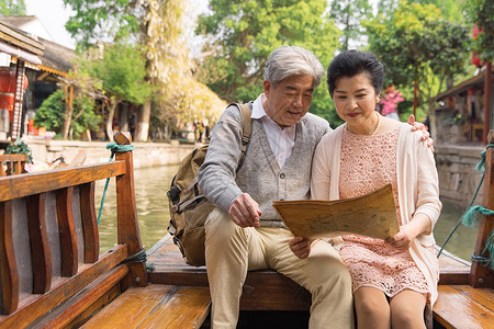 老年夫妻古镇游船看地图背景图片