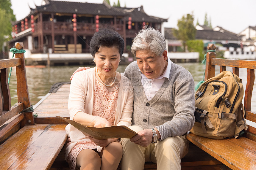 老年恩爱夫妻游船上看地图图片