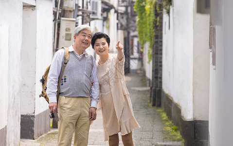 老年夫妻在古镇巷子游玩背景图片