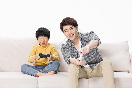 父子居家玩电子游戏父子居家沙发上玩电子游戏背景