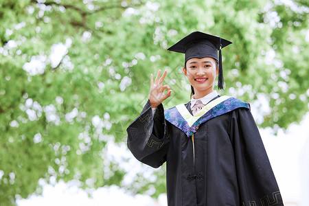 带着学位帽的女生手举毕业证书庆祝毕业ok手势背景