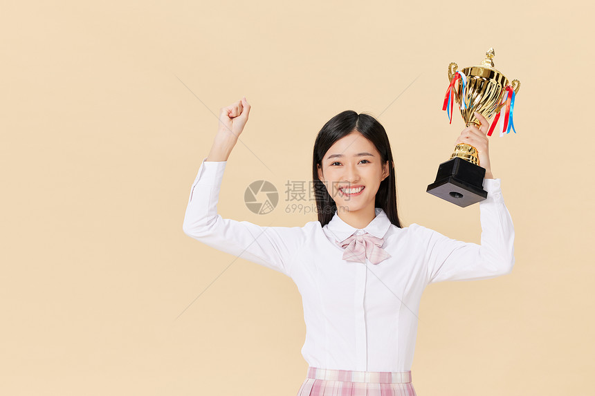 开心地举着奖杯的女学生图片