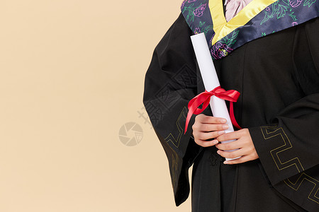 拿毕业证穿着学士服的人背景图片