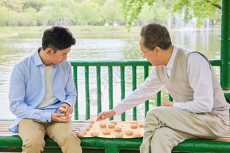 老年父子公园湖边下象棋图片