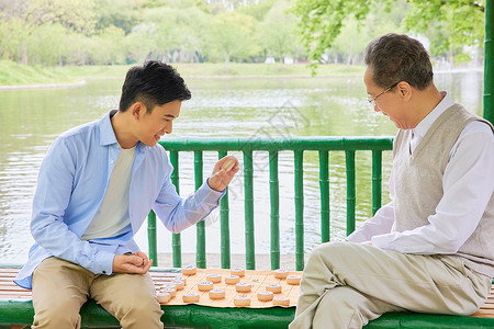 老年父子公园湖边下象棋图片