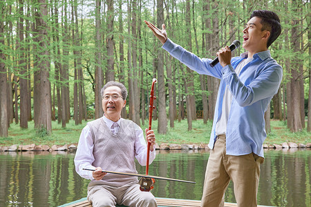 中年父子公园湖边拉二胡唱歌背景图片