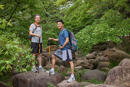 背包拍照老人中年父子拿登山仗徒步郊游背景