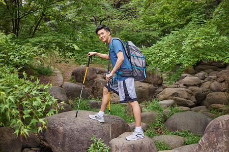 青年男性拿登山杖徒步图片