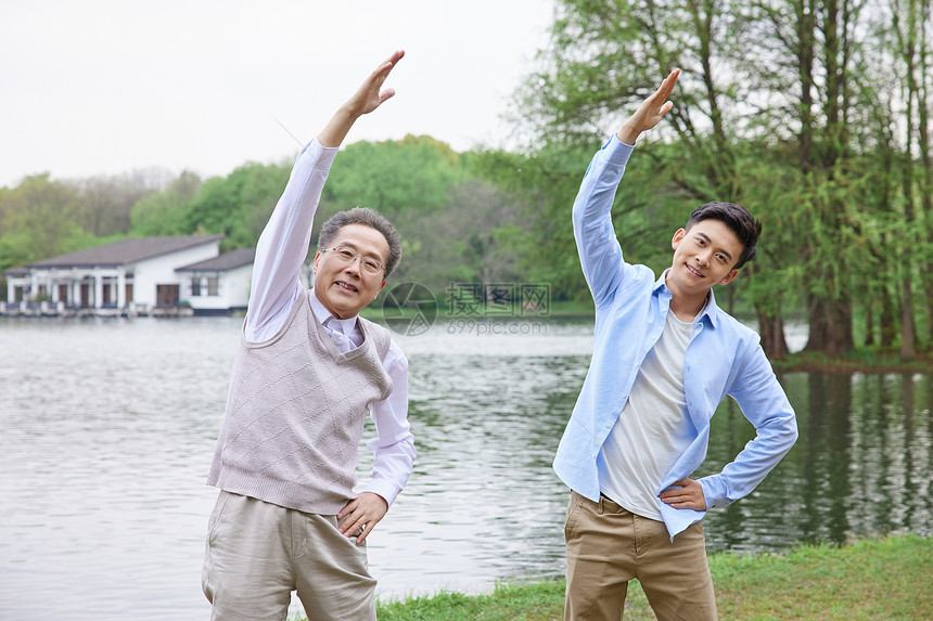 中年父子湖边做热身运动图片