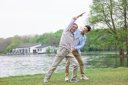 中年父子公园湖边打太极拳背景图片