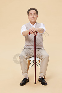 老爷爷坐椅子上拄拐杖背景图片