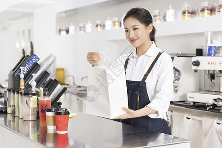 外卖服务饮品店女性服务员递出外卖奶茶背景