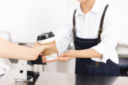 饮品店女性服务员端着咖啡背景图片