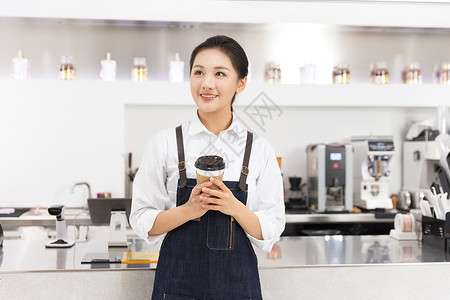 饮品店女性服务员端着咖啡背景图片