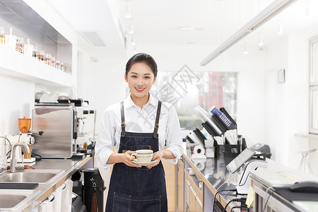 饮品店女性服务员端着咖啡背景图片
