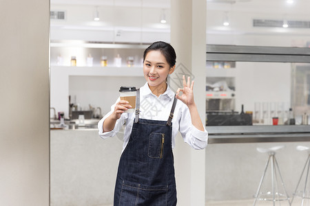 饮品店女性服务员端着咖啡背景图片