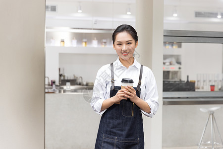 饮品店女性服务员端着咖啡背景图片