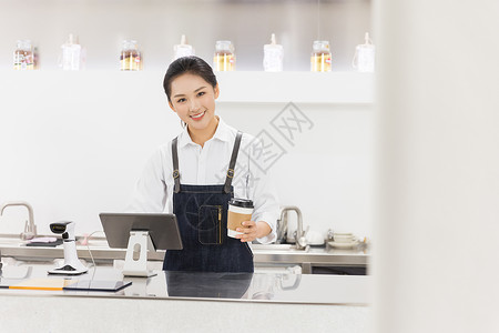 饮品店女性服务员端着咖啡背景图片