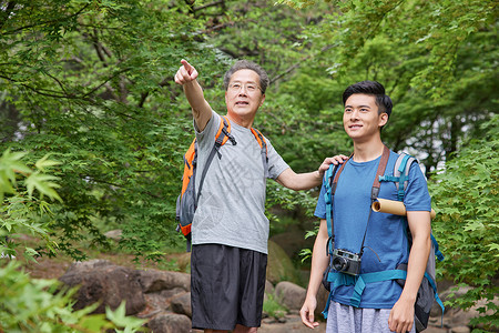 背包拍照老人中年父子相伴户外郊游背景