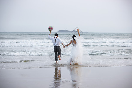 海边沙滩情侣夫妻奔向大海高清图片