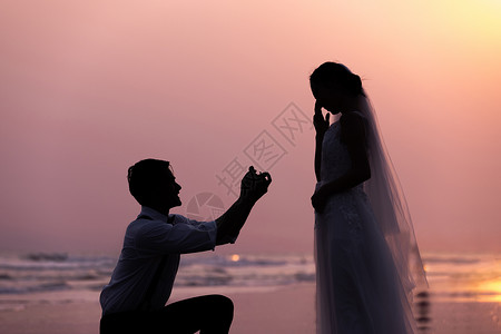 海边沙滩日落情侣求婚剪影高清图片