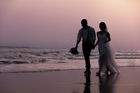 夏日海边青年情侣婚纱照海边沙滩日落情侣散步剪影背景
