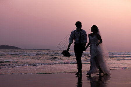 夏日海边青年情侣婚纱照海边沙滩日落情侣散步剪影背景