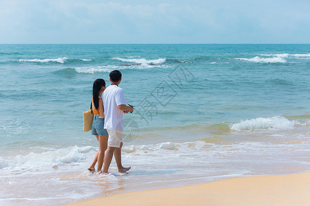 钓鱼情侣夏日情侣海边沙滩散步背景