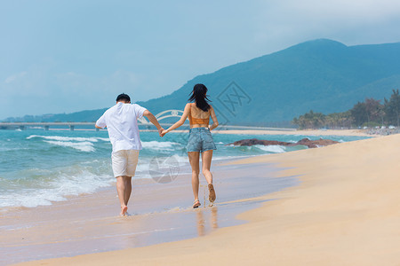 夏日情侣海边沙滩上奔跑戏水图片